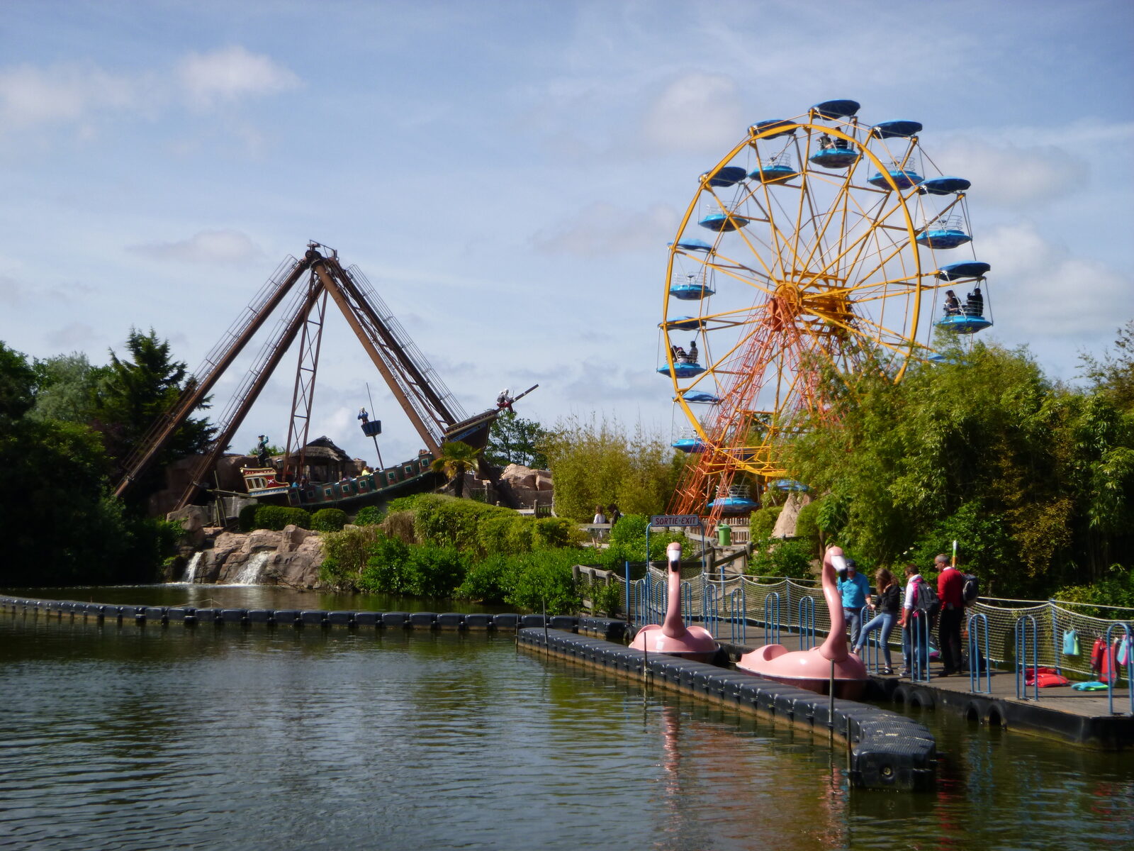 Le lac du parc Bagatelle, avec le bateau pirate, la grande roue et des pédalos en forme de flamants roses le long du ponton